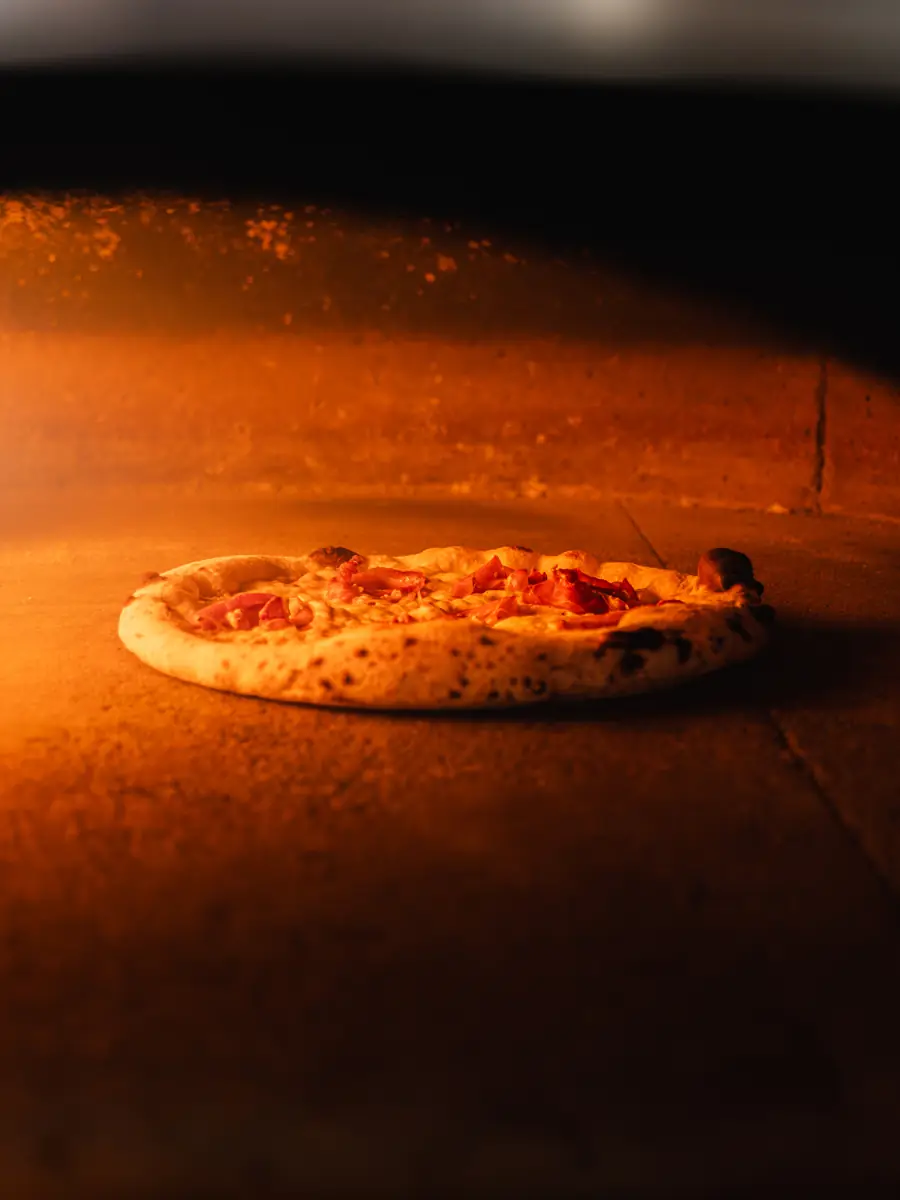 Une pizza dans le four à bois