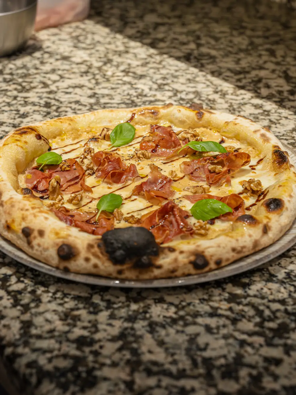 Pizza au jambon cru et basilic sortie du four